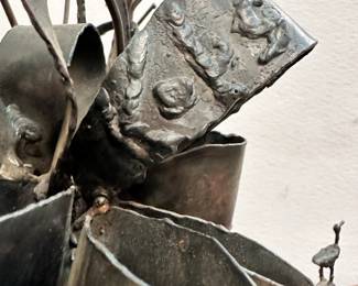 Closeup of the figural metal sculpture by Simon Kops. The sculpture by Simon Kops is signed Kops on the back of the figure's hat.
