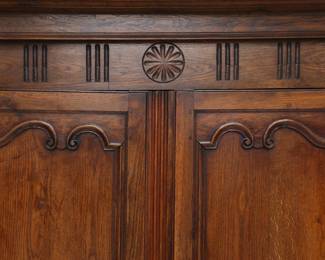 Closeup of a French 19th Century carved wooden two door cupboard or armoire with internal shelving and two drawers