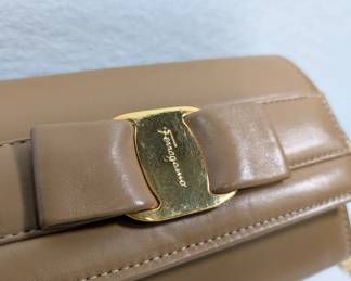 Closeup of vintage Ferragamo Vara Bow continental wallet camel color bag clutch with gold tone chain strap