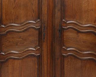 Closeup of a French 19th Century carved wooden two door cupboard or armoire with internal shelving and two drawers
