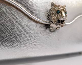 Closeup of the vintage Saks Fifth Avenue small silver metallic evening bag clutch purse with jeweled tiger clasp