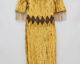 A glittering gold sequin dress, diamond pattern net insert at waist, beaded fringe sleeves and hem