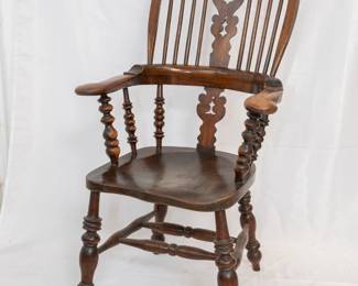 The third of three antique mid 19th century English broad arm Windsor chairs
