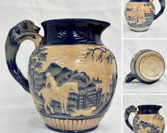 A beautiful antique Wedgwood hunting scene pitcher with hound shaped handle, applied figures in relief and overglaze blue and cream enamel; this design is also known as the "Dye Ken John Peel" pitcher.