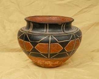 A lovely large old Santo Domingo Pottery pot of the "Aguilar Type." Asunción Aguilar Caté and Felipita Aguilar Garcia, along with their sister-in-law, Mrs. Ramos Aguilar-are credited with this innovative style. They began experimenting around 1910 and introduced bold new patterns that used large areas of black and red, outlined with delicate cream lines. This departure from traditional techniques made their pottery highly sought after.