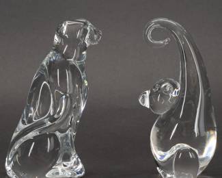 Steuben Glass Cheetah and Swinging Monkey Figurines - The grace and liveliness of the wilderness in two sparkling art glass sculptures from Steuben. Cheetah model No. 9597VAA designed by Taf Lebel Schaefer and introduced in 2010, and a swinging Monkey model No. 8892 designed by Katherine de Sousa and introduced in 1973. Both hand formed and engraved with Steuben on the base. Cheetah 3-1/4 inches L x 6 1/4 inches H, Monkey 3 inches L x 6-1/4 inches H.
