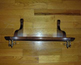 Wall shelf with small gold-ish railing detail.