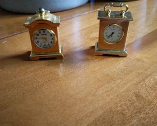 Tiny gold metal shelf clocks for decor.
