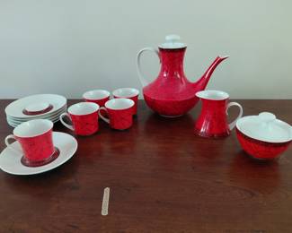 Red marble patterned tea set. Has 1 sugar bowl, 1 cream jug, 6 saucers, 5 cups, and 1 tea pot.