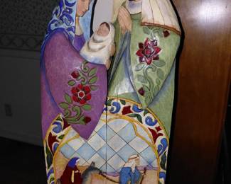 Mary, Joseph, and baby Jesus statues. Colorfully decorated and has scenery included on it.