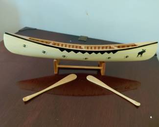 Cream wooden canoe with moose pattern and oars. Shelf decor.