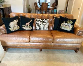Fabulous leather sofa , safari needlepoint pillows