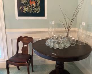 Round wooden table $150, Vintage Hazel Atlas Williams clear glass 25pc. punch bowl set $75, Charleston etched large globes, each $60, Empire chair with original leather seat $30, “Monkey Business” art print by Megan Galante $75 firm