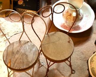 Two iron ice cream chairs with unfinished seats and washstand bowl and pitcher.