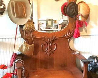 American oak mirrored hall tree with vintage cowboy and lady's hats.
