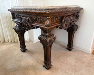 Appears to be a marble topped square coffee table which features an intricately carved base. Made in China. H 21" x W 42" x D 42". Matches lots 92 and 94. Receipt from consignor shows Ashley as the brand of furniture.