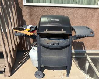 Char-broil gas grill. Compact size. Includes propane bottle. Weathered from outdoor storage. Very clean interior. H 38" x W 47" x D 17". Untested. Accessories as shown in photos.