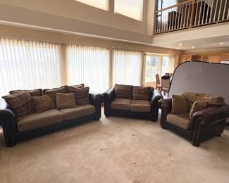 Living room suite which includes a matching faux leather sofa, loveseat and oversized chair. Tweed cushions. No manufacturer found. Chair has some sun fading. Sofa H 32" x W 92" x D 41". Loveseat H 32" x W 70" x D 41". Chair H 32" x W 48" x D 40".
