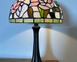 Tiffany style lamp, made in the USA. Plastic shade and heavy bronze base. H 20" x 12" diameter. Powers on.