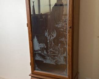 Wood and glass gun cabinet with an etched glass door featuring a dear and nature scene, H 72" x W 22 1/2" x D 16 ", includes (2) keys, unknown manufacturer.