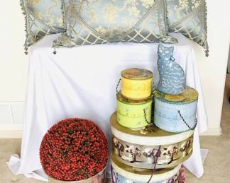 Six (6) decorative hat boxes ranging in size from H 5" x 6" diameter to H 7" x W 13" x D 17". Three (3) light blue and tan ornate brocade pillows with feather inserts. Brass planter H 11" x 14" diameter.