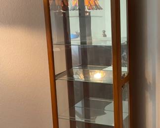 Pulaski Furniture Corp. Curio Cabinet. The cabinet is tantone with glass side and front windows, H 75" x W 21 1/2" x D 10 1/2", (4) glass shelves, doors open from the side. Interior light does not power on.