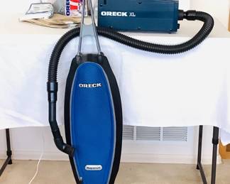 Oreck Magnesium upright vacuum cleaner, powers on. Includes owner's packet and (2) new bags of vacuum bags. Model LW1500RS. Oreck xl handheld canister vacuum, powers on. Model BB870-AUS.
