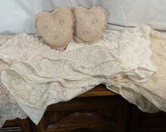 Three (3) lace tablecloths- (1) rectangle, (1) round and (1) square. Three (3) crochet table runners. Two (2) heart shaped accent pillows, approximately 10" x 8".