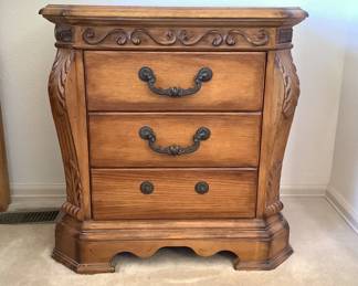 Pair of wood nightstands featuring intricate accents. Minor nicks and scratches and water marks on surface. H 28" x W 27" x D 16". One handle is broken off of one of the nightstands, but IS included. Matches lots 1 and 9. Receipt from consignor shows Ashley as the brand of furniture.