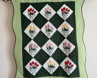 Quilted wall hanging featuring a floral vase design. Appears to be machine finished. Includes hanging rod. Bring tools to remove from wall and step stool. H 57" x W 48".