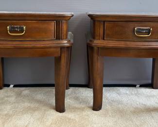 Pair of matching wood veneer end tables, each featuring (1) drawer with bronze toned and faux leather hardware. Faux leather is worn. Nicks and scratches as well as sun fading on each piece. No manufacturer found. Made in China. H 25" x W 26" x D 10". Matches lot 139.
