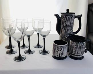 Three (3) pieces of medieval style drinkware which includes a pitcher with lid H 10" x 4" diameter, a small pitcher H 5" x 3" diameter and a mug H 4" x 3" diameter. All items are unmarked and in good condition. Seven (7) clear glass wine glasses with black stems, H 8" x 3" diameter.