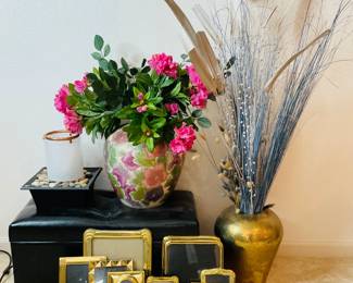 Faux leather footstool/ottoman H 12" x W 28" x D 13". Hammered brass vase with faux reeds, H 15" x 15" diameter. Tabletop fountain, unknown working condition. H 10" x 10" square. Chinoiserie vase, H 13" x 14" diameter. An assortment of gold toned picture frames.