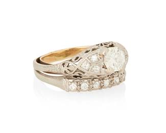 1087
A 14K White Gold and Diamond Ring Set
Centering a round diamond weighing approximately 0.75 carats accented by round diamonds set in a filigree design with a soldered 14k gold and round diamond band
Size; 7 1/4 with sizing spring
6.17 grams gross
Estimate: $700 - $900