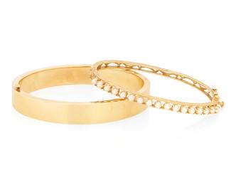 1048
Two 14K Gold Bangles
One of hinged scrolling design featuring seventeen cultured pearls together with a high polish hinged design bangle
2 pieces
Inner circumference: 6 1/2 and 7 in.
32.1 grams gross
Estimate: $1,200 - $1,800