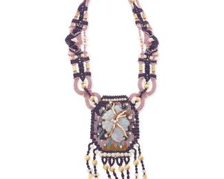 1164
Barbara Natoli Witt: A Cavandoli Macramé and Carved Opal Necklace
With elaborate knotwork in purple, lilac, and tan cord, featuring a carved opal stone fish plaque and opal and 14k gold beads and beaded fringe, circa 1974, signed and dated to ceramic bead
Measures: 36 in. x 6.5 in.
60.6 grams gross
Estimate: $800 - $1,200