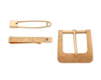 1115
A Group of 14K Gold Jewelry
Including a Tiffany & Co. tie pin featuring a round sapphire, a gold belt buckle and gold safety pin
3 pieces
Measures: 1 7/8, 1 3/4 and 1 3/4 in.
25.3 grams gross
Estimate: $1,000 - $2,000