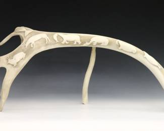 A 20th century Inuit carved Caribou antler from the Pangnirtung hamlet, Qikiqtaaluk Region, Canada. Decorated with nine carved relief images of animals, propped against a smaller piece of antler. Retains original "Canadian Eskimo Art" Igloo tag. Minor wear. Approx. 25 1/2 x 9 3/4" high overall when propped. ESTIMATE $400-600