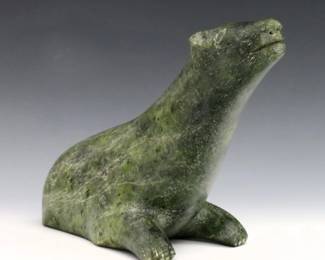 Attributed to Tuckyashuk, Inuit (Cape Dorset/Kinngait), 1898-1972. A 20th century carved Serpentine figure of a seated polar bear. Unsigned, retains paper label at underside citing artist as "Tuckyashuk" at underside. Minor surface wear. 10 x 6" high overall. ESTIMATE $200-300