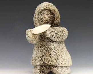 A 20th century Inuit carved Whale bone figure of a hunter from the Pangnirtung hamlet, Qikiqtaaluk Region, Canada. Depicted kneeling with a polished bone knife. Unsigned, retains original "Eskimo" art tag citing artist as "Noah" (n.d.). Minor wear. 7 3/4" high. ESTIMATE $200-400