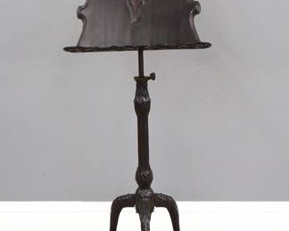 A late 19th century Victorian Period music stand. Mahogany construction with a shaped music rack with a shaped, reticulated frame with adjustable height and tilt mechanism on a carved stem and tripod base with cabriole lags. Older finish with some wear and minor damage. 24 x 15 x 64" high overall. ESTIMATE $200-300