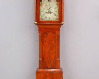 An early 19th century American Federal Period Grandfather clock. 8-day weight driven time and strike movement with a painted Iron dial with Roman numerals, subsidiary seconds and upper moon phase dial. Mahogany case with a broken arch top and inlaid detail. Older refinishing with some wear, areas of veneer loss, dial wear, running when cataloged. 84" high overall. ESTIMATE $400-600