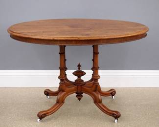 A 19th century Victorian Period center table. Walnut construction with an oval molded top and beaded apron over a base with four turned columns and shaped legs around a central turned finial. Refinished with minor wear. 46 x 33 x 29 1/2" high overall. ESTIMATE $200-300