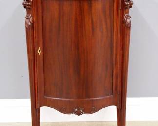 A late 19th century Victorian Period music cabinet. Mahogany construction with a shaped molded top and conforming door flanked by Lion's mask corner columns ending in cabriole legs. Older refinishing with slight wear. 26 x 16 x 42" high overall. ESTIMATE $200-300