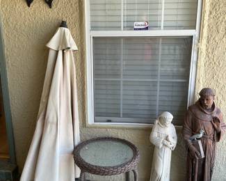 Glass round small table, St. Francis statue, umbrella, & butterfly wall decor