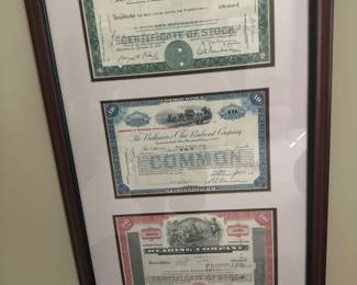Three vintage stock certificates from railroad companies famously featured in the game Monopoly
