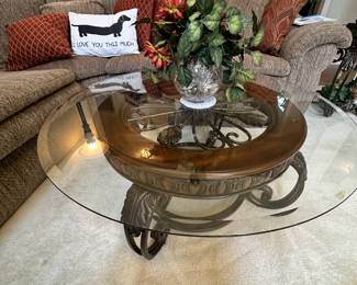 round glass coffee table, lots of decorative pillows, faux plants, vases, and more