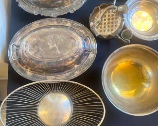 silver serving items, including trays, bowls, and utensils. 