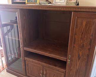 Entertainment Center with storage, lots of picture frames, and lamps.