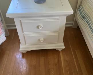 This is a white end table that goes with the four piece piece bedroom set